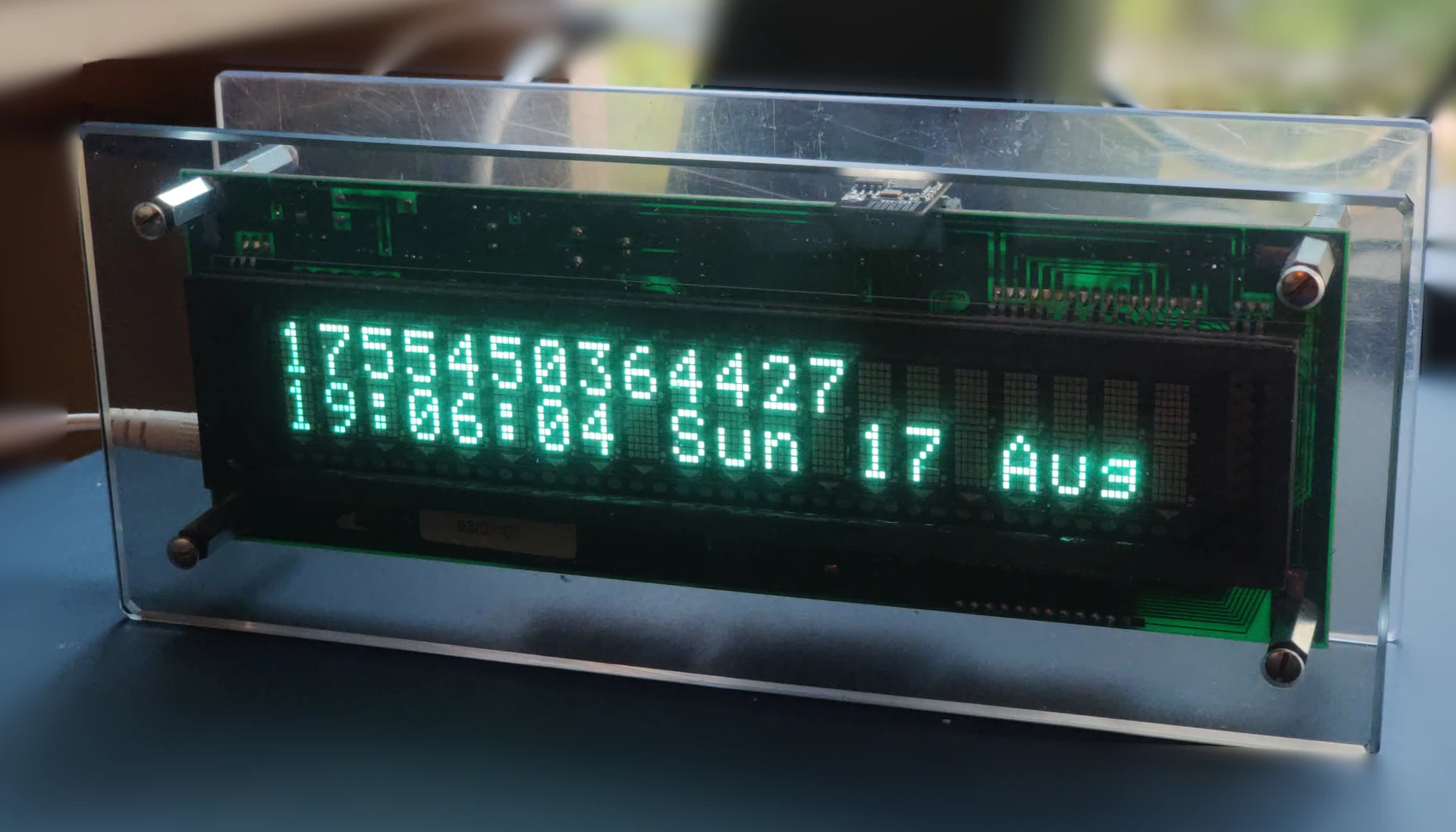 VFD from the front, one line showing a UNIX timestamp and another line showing a human readable datetime